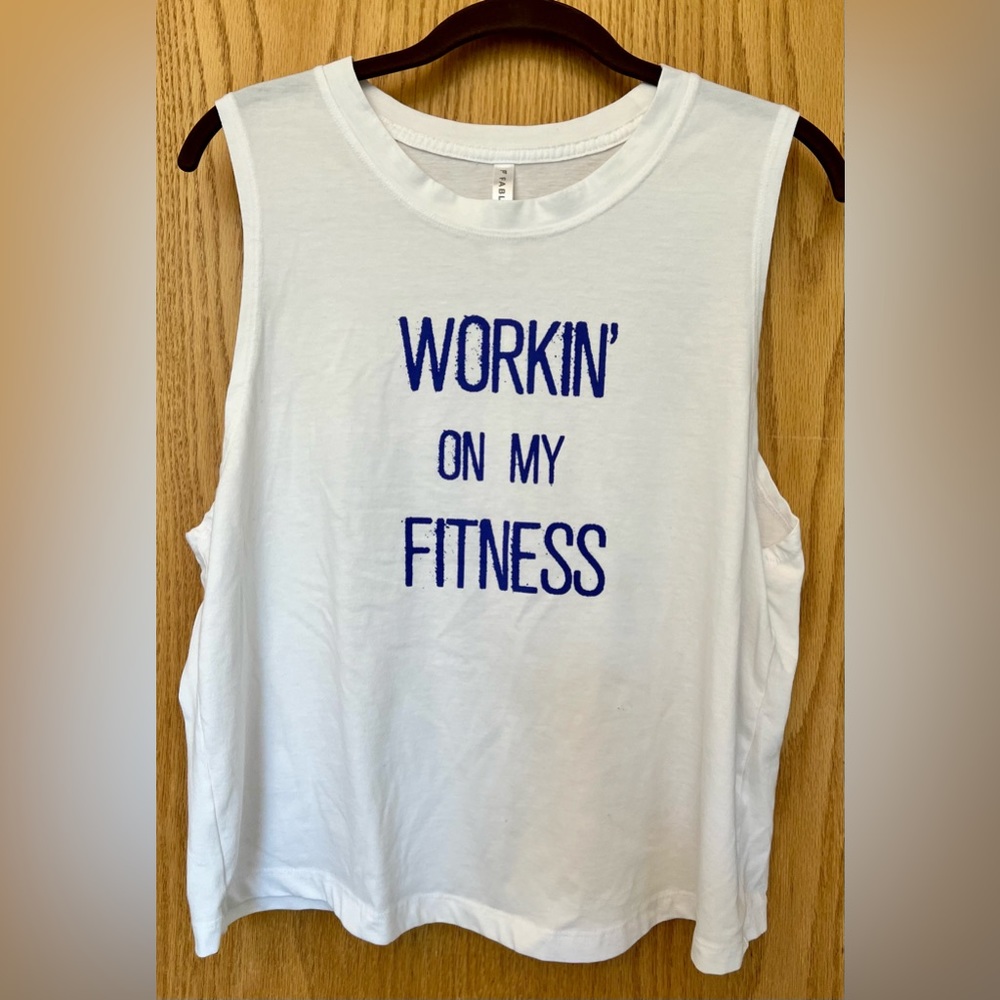 Fabletics size Medium tank top, white with saying "Workin on my fitness"